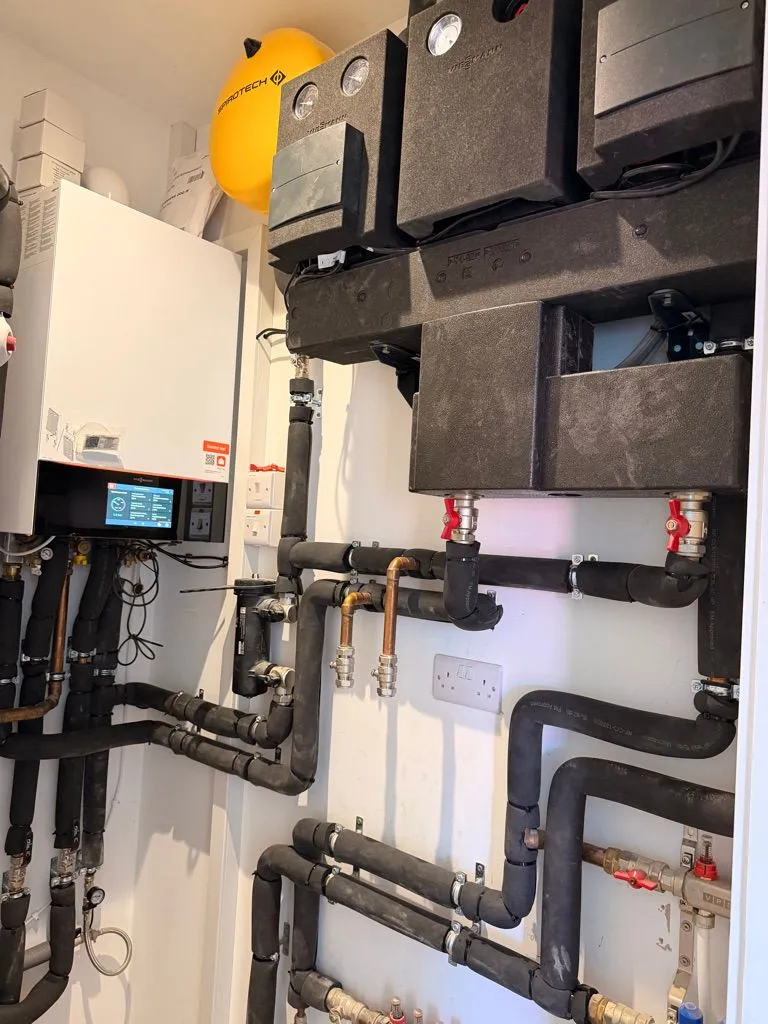 Viessmann boiler, heating manifold and insulated pipework installed in a plant cupboard