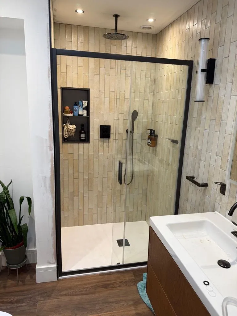 Completed bathroom with tiled walk-in shower enclosure and basin