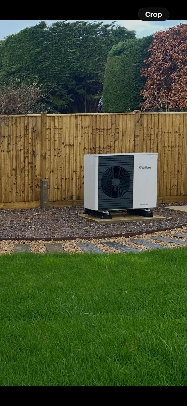 Vaillant air source heat pump installed on a plinth in a garden