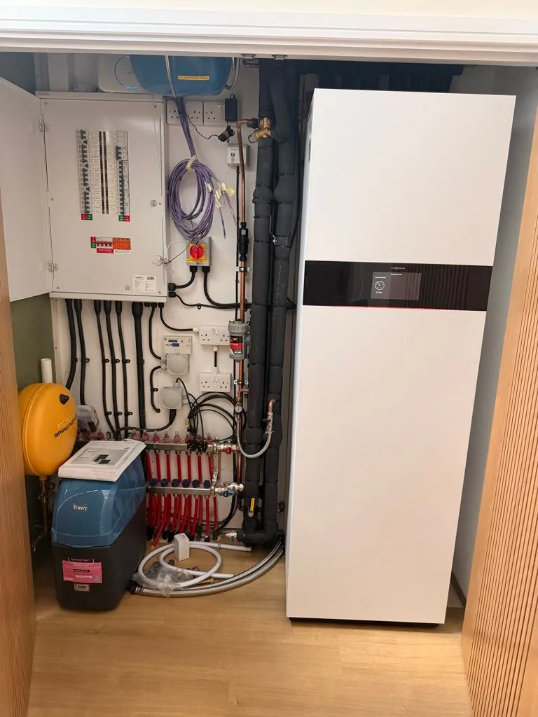 Hot water cylinder, underfloor heating manifold, water softener and controls in a plant cupboard