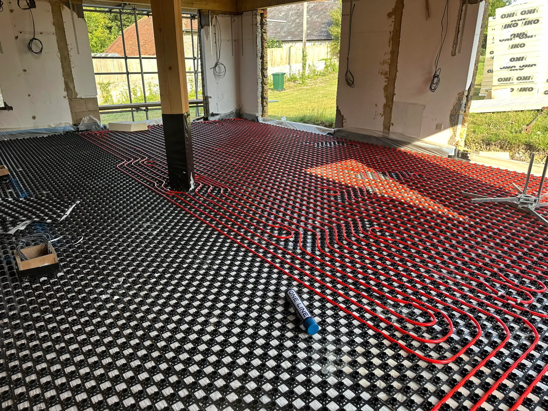 Underfloor heating pipe laid in castellated panels during a house renovation