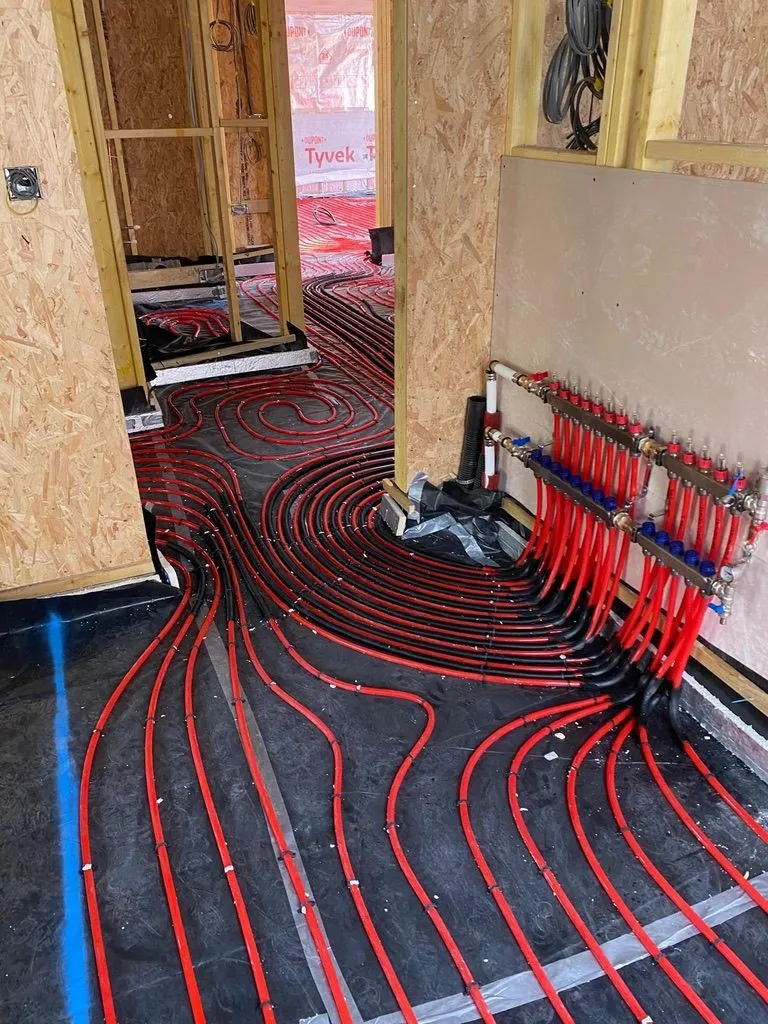 Underfloor heating pipes connected to a manifold during a new build installation